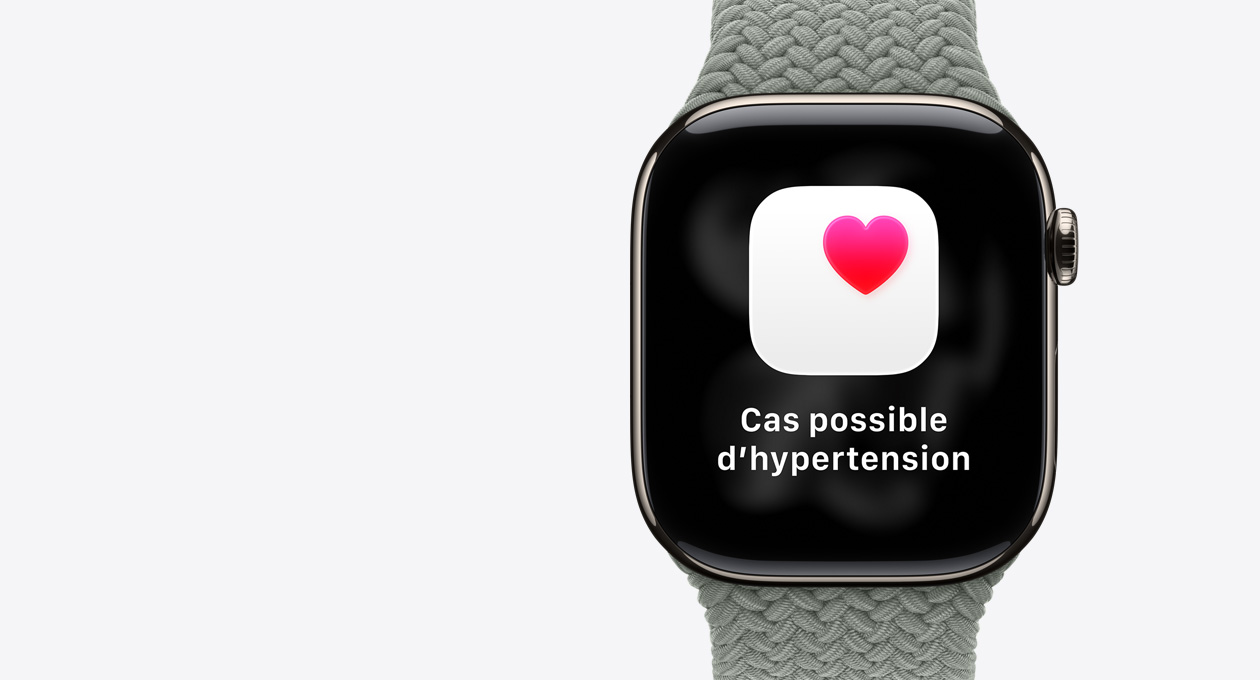 Apple Watch Series 11, naturel, boîtier en titane, notification de cas possible d’hypertension, cœur rose dans un encadré blanc, côté droit, Digital Crown, bracelet solo tressé gris-vert