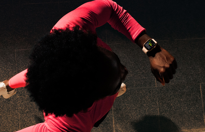 Une personne vérifiant ses progrès dans l’app Exercice d’Apple Watch Series 11 en courant