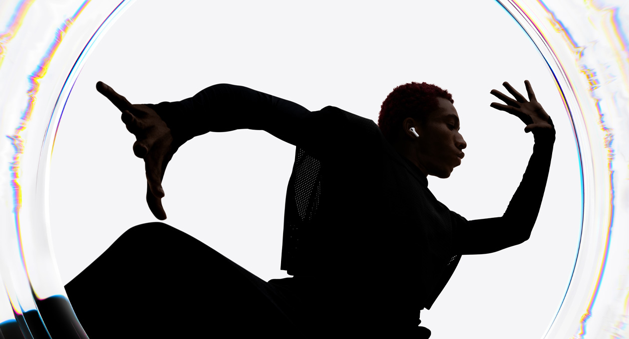 En danser med AirPods Pro 3 i ørerne bevæger sig til musik med armene bredt ud