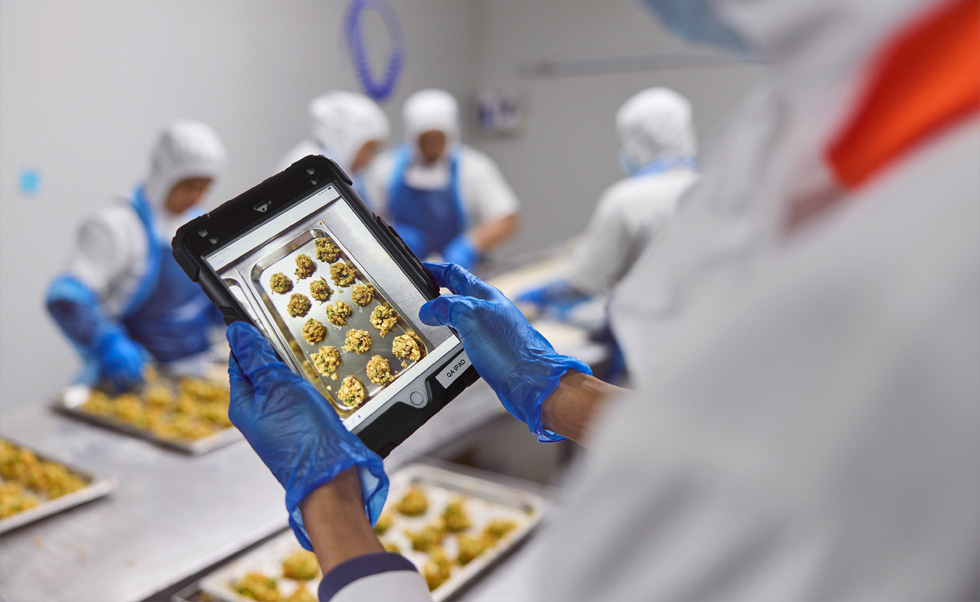 Egy alkalmazott iPaden végez minőség-ellenőrzést.