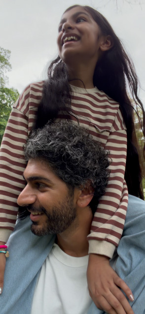 iPhone 17 screen demonstrating stabilized video recording as man carries young girl on his shoulders